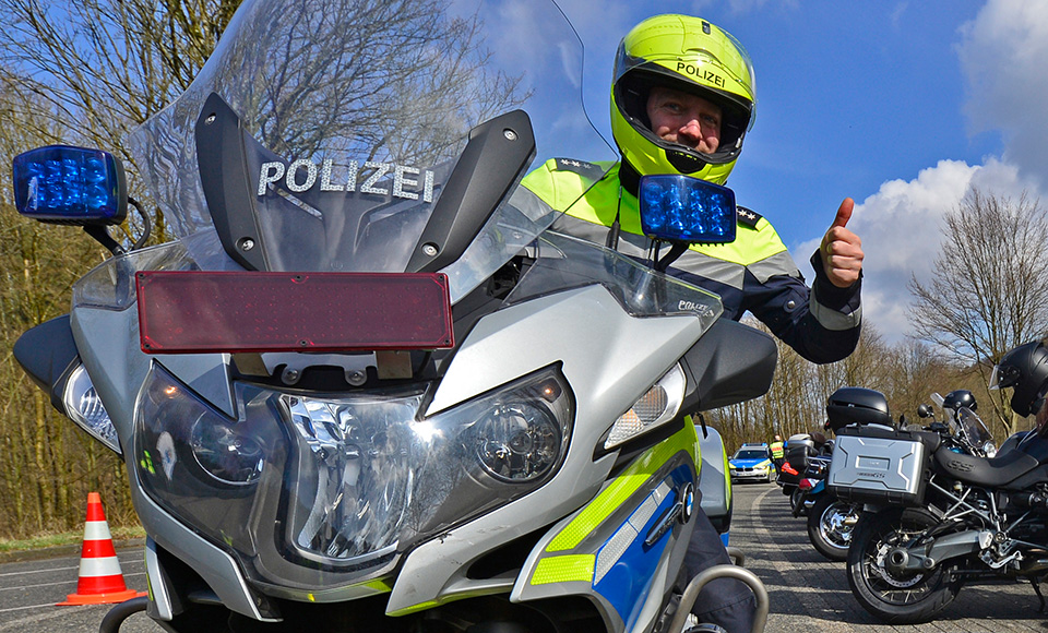 Polizist auf Motorrad Daumen hoch