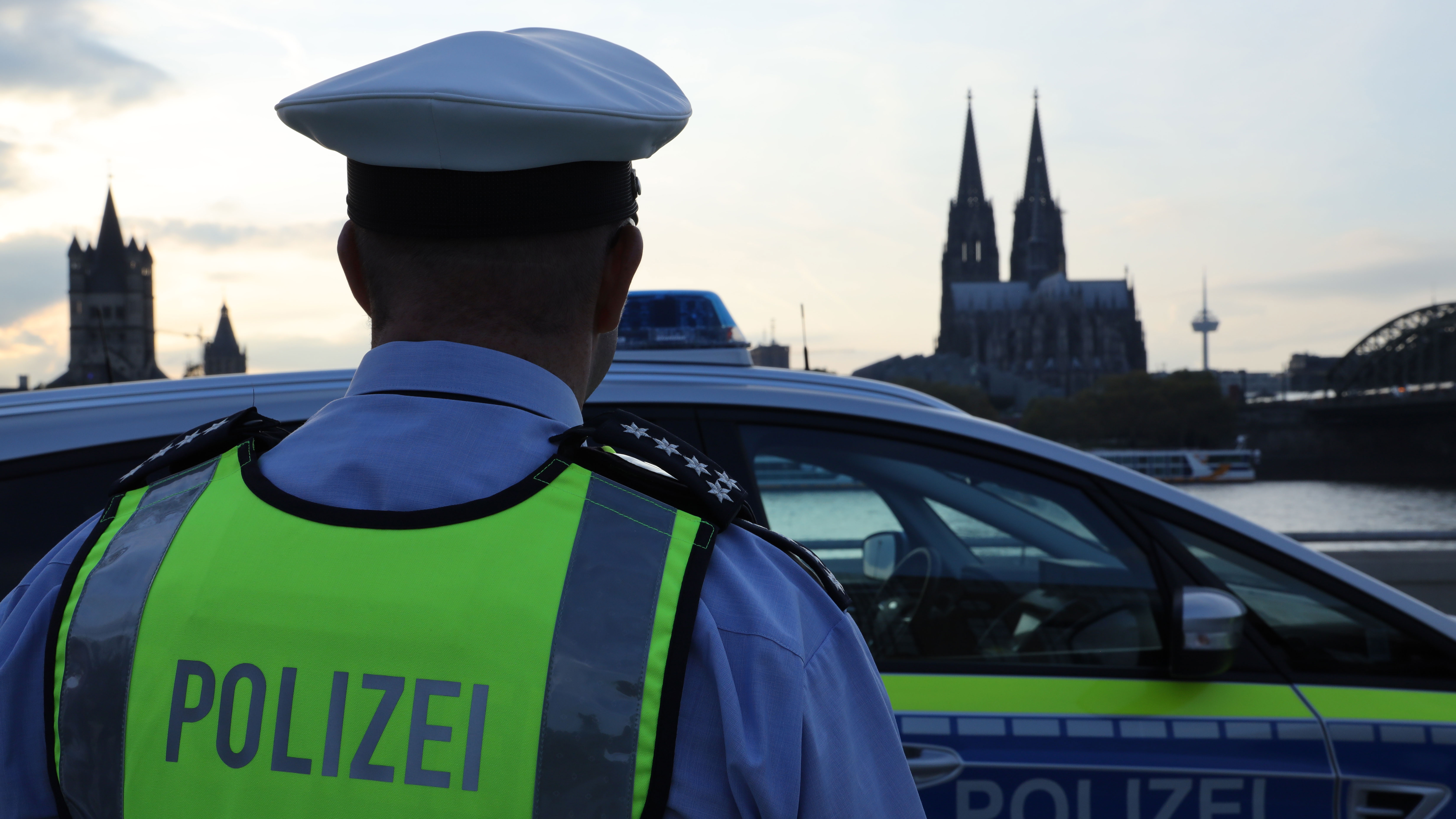 Polizist vor Streifenwagen in Köln