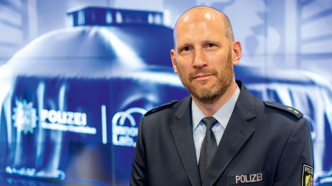 Dominic Reese vom LZPD NRW steht vor einer Videowand